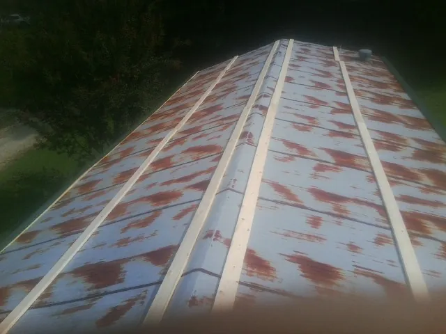 Rusted metal roof panels with new wood purlins before replacement — Storm Damage Roof Repair in Makoti by Roofing Brothers