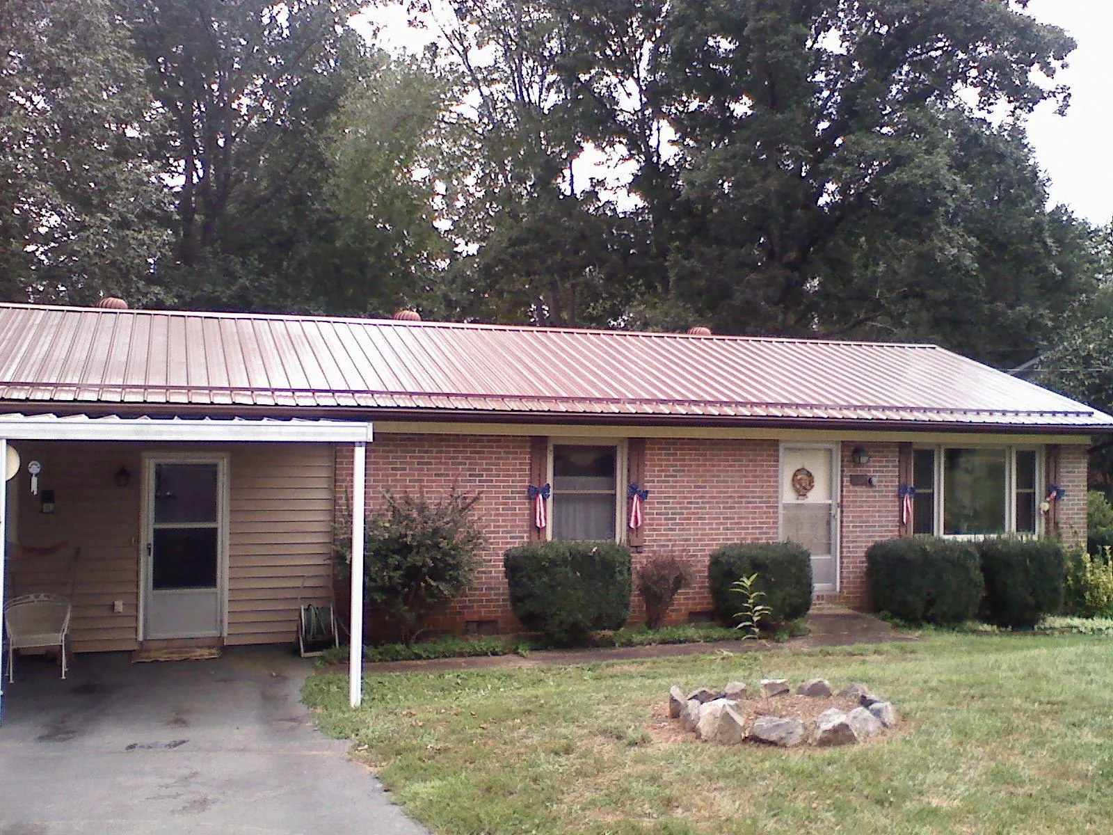 Bronze metal roof and carport on a brick ranch home — Roof Repair work by our crew in Makoti